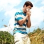 mezőn álló tüsszentő férfi, szénanátha, allergiás rhinitis